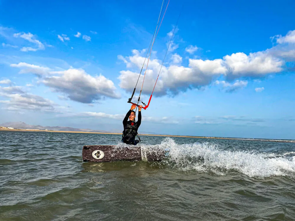 Kitecamp Fehmarn: Kiterin mit Kitemonkey-Board carvt durchs Flachwasser am Fehmarnsund